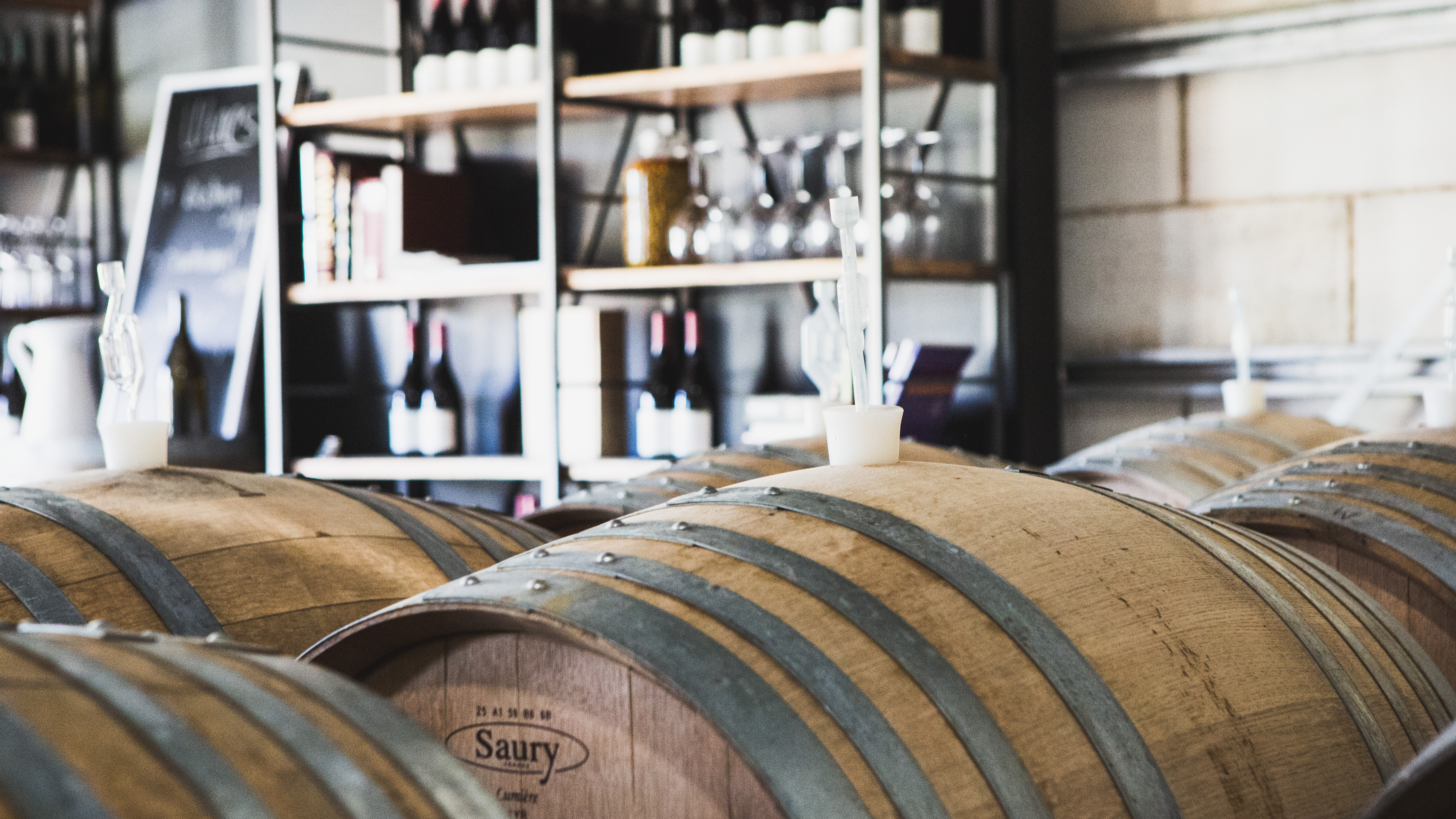 Barrels and display of wine bottles 